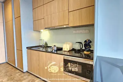a kitchen with wooden cabinets and a counter top at Expressionz Premium Suites @ KLCC in Kuala Lumpur