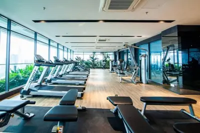 a gym with a row of treadms and machines at Maxhome at The Luxe By Infinitum in Kuala Lumpur