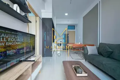 a living room with a green couch and a tv at Maxhome at The Luxe By Infinitum in Kuala Lumpur