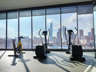 a gym with cardio machines in front of a large window at City-View Studio Retreat with Spectacular View TRX in Kuala Lumpur