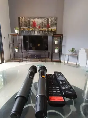 two remote controls sitting on a table next to a television at Titiwangsa9 Bungalow Pool Villa in Kuala Lumpur
