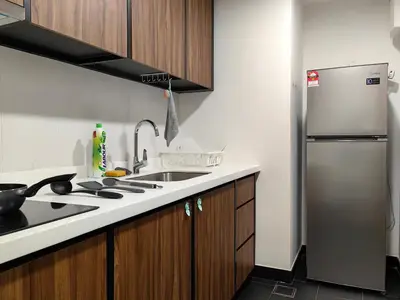 a kitchen with a sink and a refrigerator at Una Serviced Apartment, Jalan Peel by Rverse Suite in Kuala Lumpur