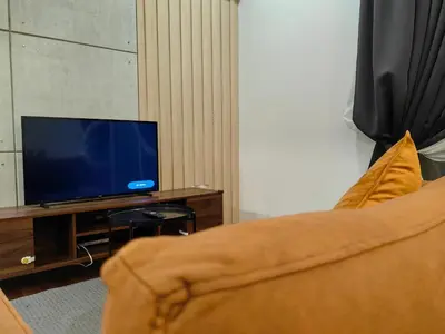 a living room with a couch and a flat screen tv at Una Serviced Apartment, Jalan Peel by Rverse Suite in Kuala Lumpur
