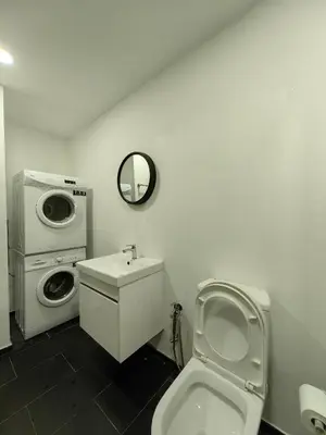 a bathroom with a toilet and a washing machine at Una Serviced Apartment, Jalan Peel by Rverse Suite in Kuala Lumpur