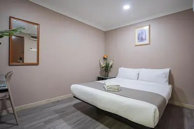 a bedroom with a bed and a table and a mirror at HOTEL 28 RAPID in Kuala Lumpur