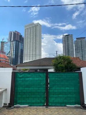 a green garage door with a city in the background at Cheras homestay @kelian in Kuala Lumpur