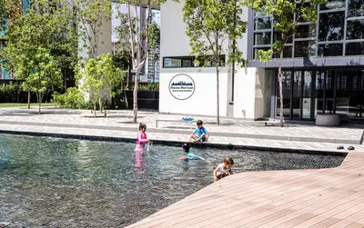 a group of children playing in the water in a fountain at Lucentia Residence by EAS Maju property in Kuala Lumpur