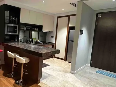 a kitchen with a counter and two bar stools at Luxurious Condo in Heart of Kuala Lumpur with Rooftop Garden in Kuala Lumpur