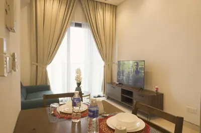 a living room with a table and a television at Lalaport Suites At Lucentia Bukit Bintang City Center in Kuala Lumpur