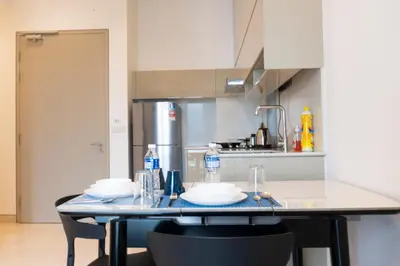 a kitchen with a table with dishes on it at Lalaport Suites At Lucentia Bukit Bintang City Center in Kuala Lumpur