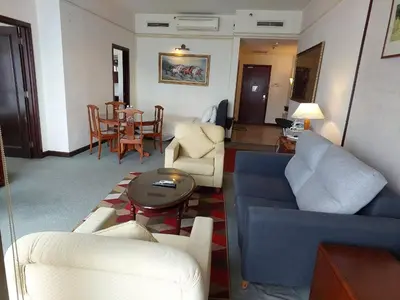 a living room with a blue couch and chairs and a table at DOUBLE DELUXE APARTMENT AT BERJAYA TIMES SQUARE kL in Kuala Lumpur