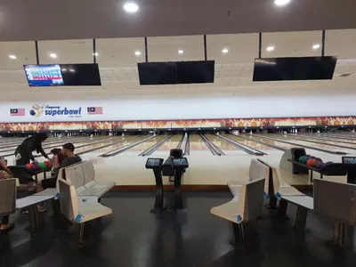 a group of people sitting in chairs at a bowling alley at DOUBLE DELUXE APARTMENT AT BERJAYA TIMES SQUARE kL in Kuala Lumpur