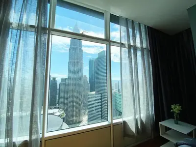 a room with a large window with a view of a city at Sky Suite @ KLCC - 3BR KLCC View in Kuala Lumpur