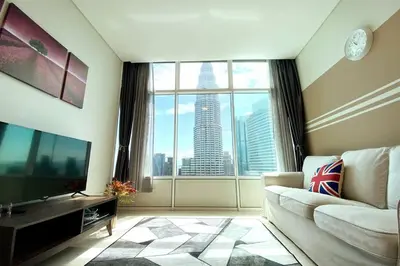 a living room with a couch and a large window at Sky Suite @ KLCC - 3BR KLCC View in Kuala Lumpur