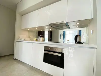 a kitchen with white cabinets and a stove at Sky Suite @ KLCC - 3BR KLCC View in Kuala Lumpur