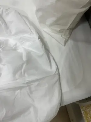 a pile of white sheets on a bed at Star residence by KLCC in Kuala Lumpur