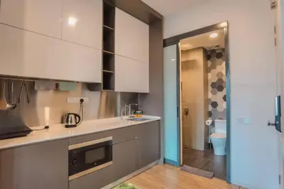 a kitchen with white cabinets and a toilet in a room at Ceylonz Suites Bukit Bintang by KL ONE in Kuala Lumpur
