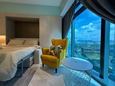 a bedroom with a bed and a yellow chair at Eaton Residences KLCC by Romeo Bnb in Kuala Lumpur