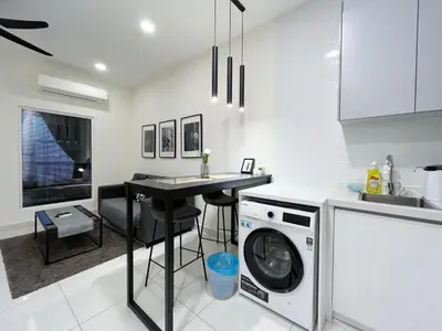 a kitchen with a washing machine and a table at Arte Mont Kiara by Yan Yee in Kuala Lumpur