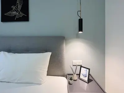 a bedroom with a bed with a white pillow and a lamp at Arte Mont Kiara by Yan Yee in Kuala Lumpur