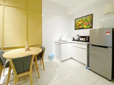 a small kitchen with a table and a refrigerator at Arte Mont Kiara by Yan Yee in Kuala Lumpur