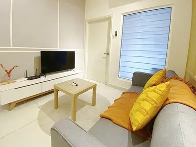 a living room with a couch and a television at Arte Mont Kiara by Yan Yee in Kuala Lumpur