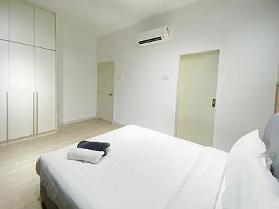 a white bedroom with a bed with two towels on it at Arte Plus Ampang in Kuala Lumpur