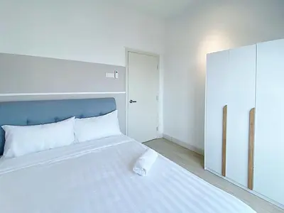 a bedroom with a white bed with a blue headboard at Arte Plus Ampang in Kuala Lumpur