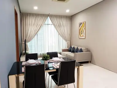 a living room with a table and chairs and a couch at Soho Suites KLCC by Minsha in Kuala Lumpur