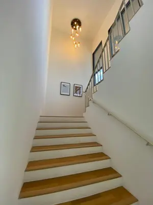 a staircase in a house with white walls and wooden floors at KL Gateway Penthouse by Cobnb - 10Pax in Kuala Lumpur