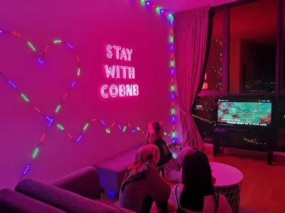 a group of people sitting in a room with a pink wall at KL Gateway Penthouse by Cobnb - 10Pax in Kuala Lumpur