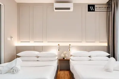 two beds with white pillows in a room at Quill Residences Suite by Mimpi B&B in Kuala Lumpur