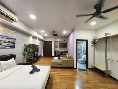 a bedroom with a bed and a living room at Regalia Suites Kuala Lumpur KLCC in Kuala Lumpur