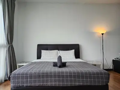 a bedroom with a bed with a black head board at Regalia Suites Kuala Lumpur KLCC in Kuala Lumpur