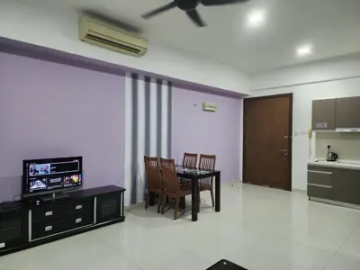 a living room with a table and chairs and a television at Regalia Suites Kuala Lumpur KLCC in Kuala Lumpur
