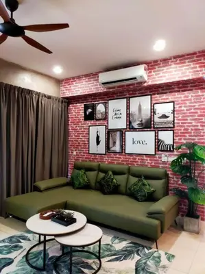 a living room with a green couch and a brick wall at Luxurious Staycation Apartment in Ampang