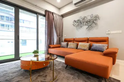 a living room with an orange couch and a glass table at Luxurious Staycation Apartment in Ampang