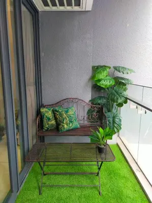 a bench sitting on a balcony with green grass at Luxurious Staycation Apartment in Ampang