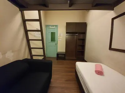 a bedroom with a bunk bed and a ladder at Travel Hub Highstreet in Kuala Lumpur