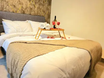 a bed with a table with two glasses of wine at Wisma Infinitum Studio 5\u5206\u949f\u62b5\u8fbe KL \u5e02\u4e2d\u5fc3 in Kuala Lumpur