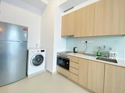 a kitchen with a refrigerator and a washing machine at Colony By Infinitum in Kuala Lumpur