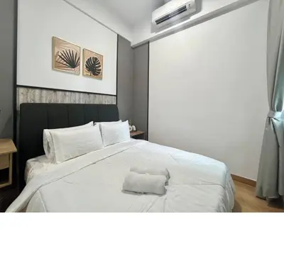 a white bed with a white towel on it at Colony By Infinitum in Kuala Lumpur