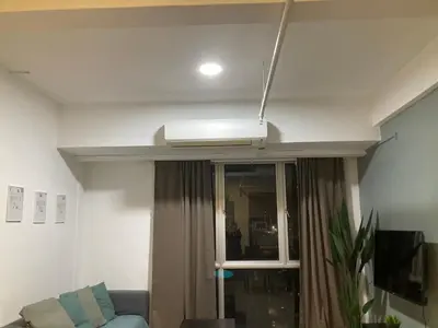 a ceiling fan in a living room with a window at Nour Homestay KLCC View - COZY 2 in Kuala Lumpur