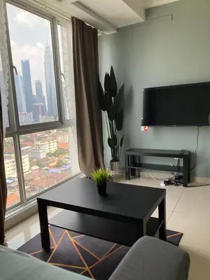 a living room with a table and a large window at Nour Homestay KLCC View - COZY 2 in Kuala Lumpur