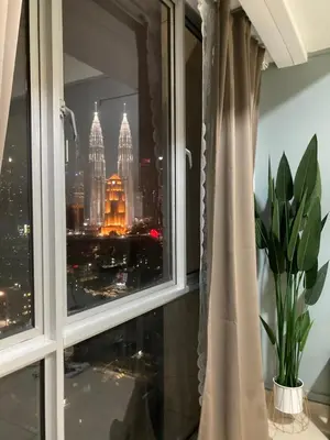 a window with a view of a city skyline at Nour Homestay KLCC View - COZY 2 in Kuala Lumpur