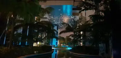 a night view of a building with palm trees at M City with Pool KLCC city view in Kuala Lumpur