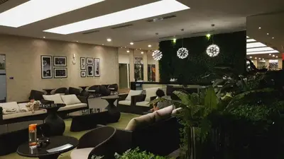 a lobby with couches and chairs and plants at M City with Pool KLCC city view in Kuala Lumpur