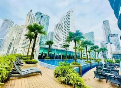 a resort with a pool and palm trees and buildings at VORTEX STAR KLCc APARTMENT in Kuala Lumpur