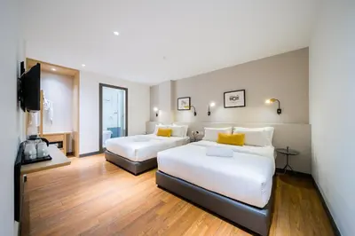 a hotel room with two beds and a flat screen tv at Gold3 Boutique Hotel in Kuala Lumpur
