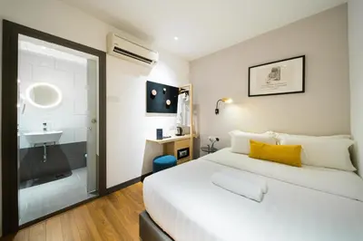 a bedroom with a large white bed and a bathroom at Gold3 Boutique Hotel in Kuala Lumpur